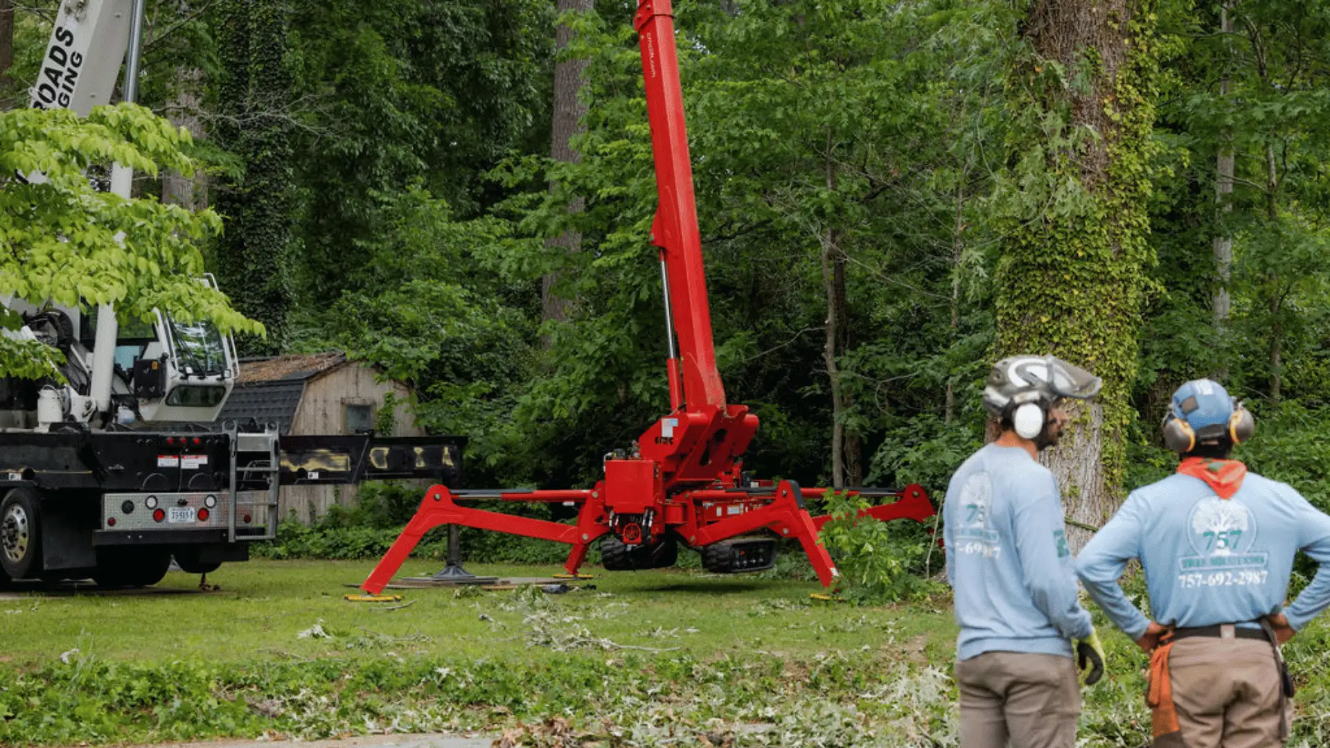 757 Tree Solutions crew members overseeing crane and bucket lift equipment on a tree removal job site